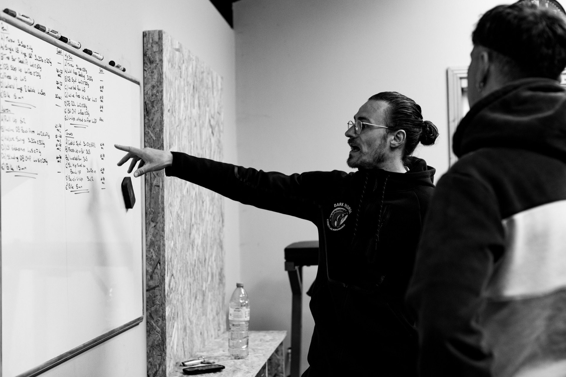 A Dark Horse coach explaining a programme at the whiteboard.